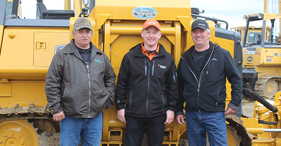 Customers standing in front of a crawler tractor Customers standing in front of a crawler tractor