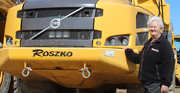 Customer standing in front of an articulated dump truck